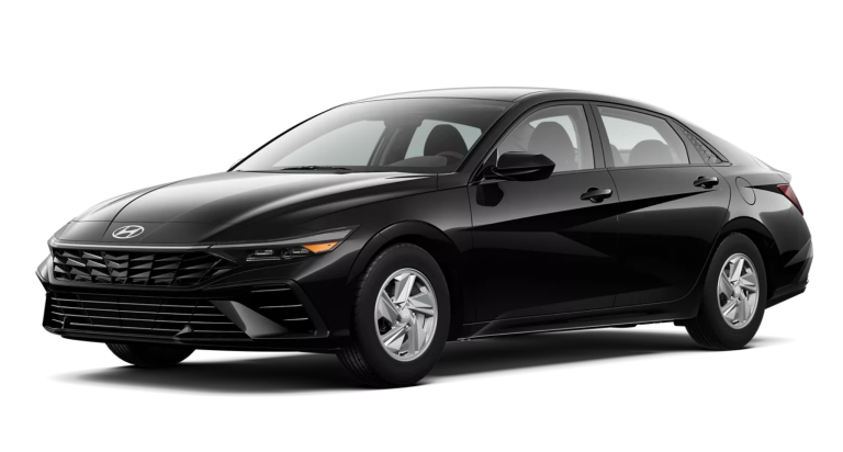 Front exterior view of the 2025 Hyundai Elantra SE showcasing its aggressive black front grille, sleek LED headlights, and bold styling for a modern compact sedan.