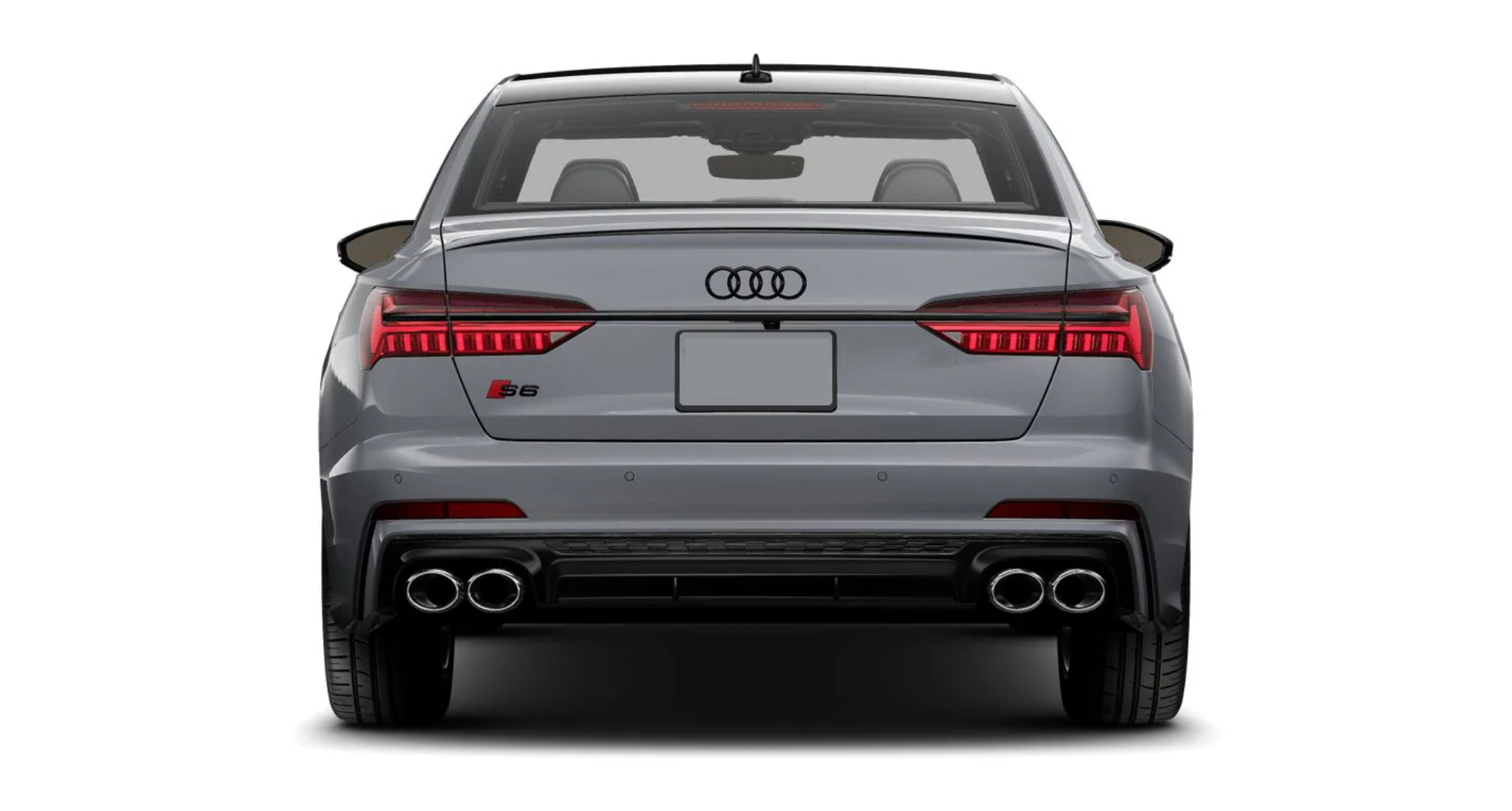 Rear exterior view of the 2025 Audi S6, showcasing its distinctive taillights, quad exhaust tips, and an aerodynamic spoiler for a sporty yet elegant look.