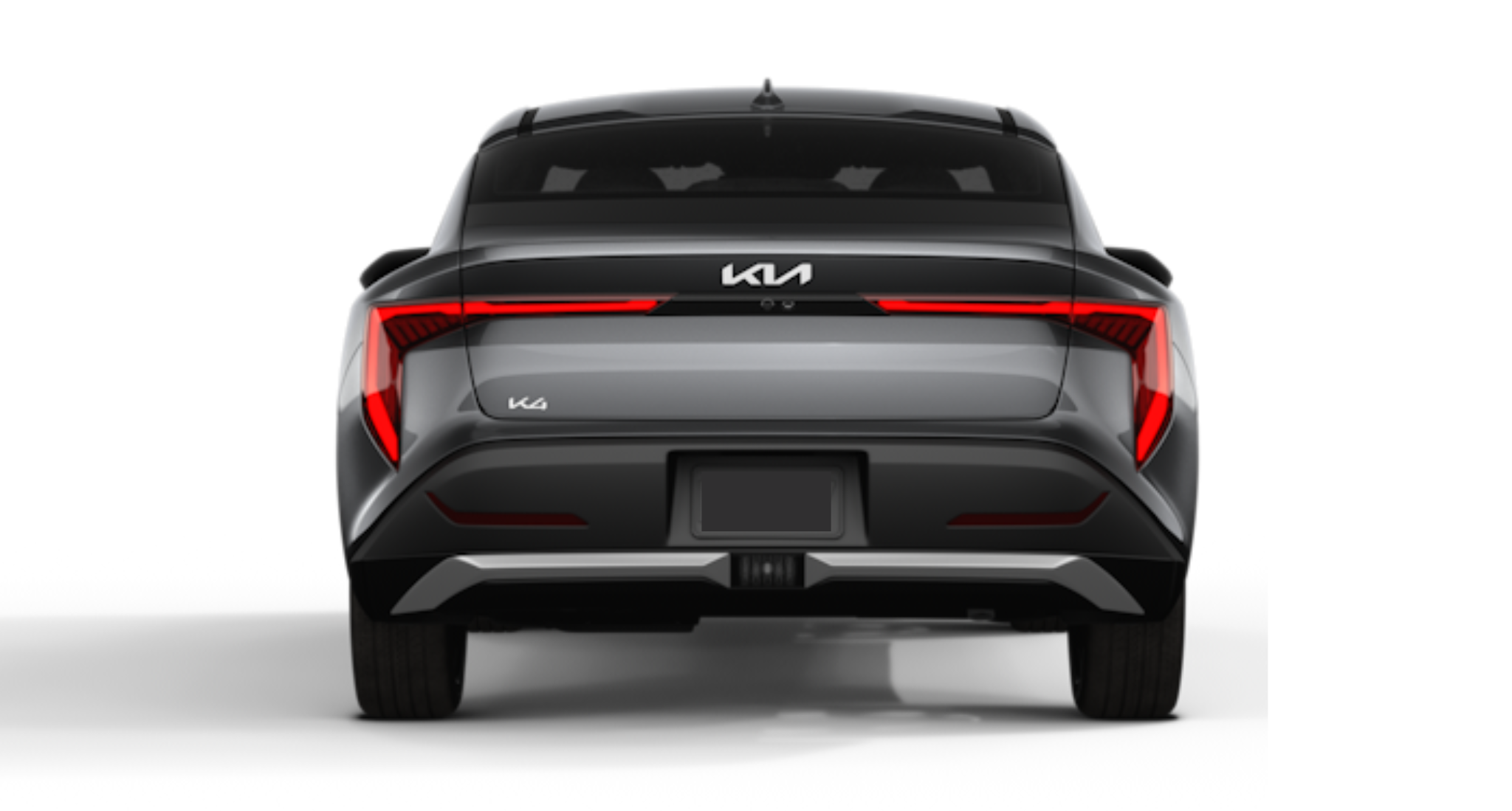 An exterior shot of the 2025 Kia K4 LX in metallic gray, featuring distinctive LED headlights, aerodynamic body lines, and a bold front grille with Kia's updated emblem.