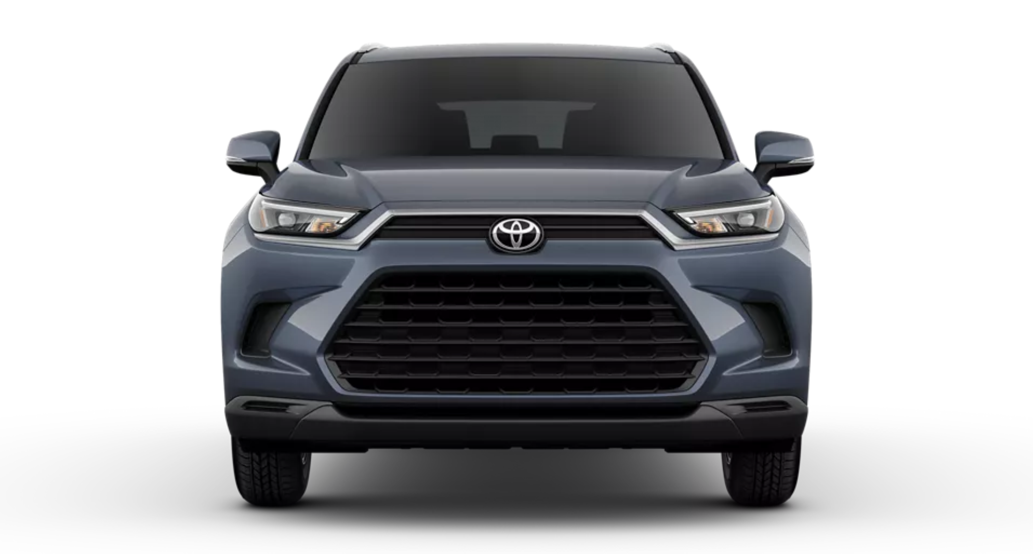 Front exterior of the 2025 Toyota Grand Highlander Hybrid LE AWD showcasing LED headlights, bold front grille, and aerodynamic hood design.