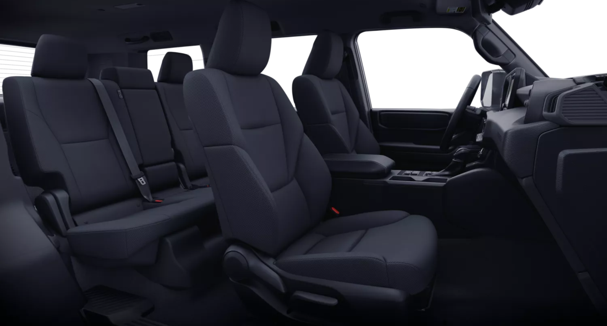 Spacious interior seating of the 2025 Toyota Land Cruiser 1958 AWD featuring durable black fabric, second-row bench, and driver-focused design.