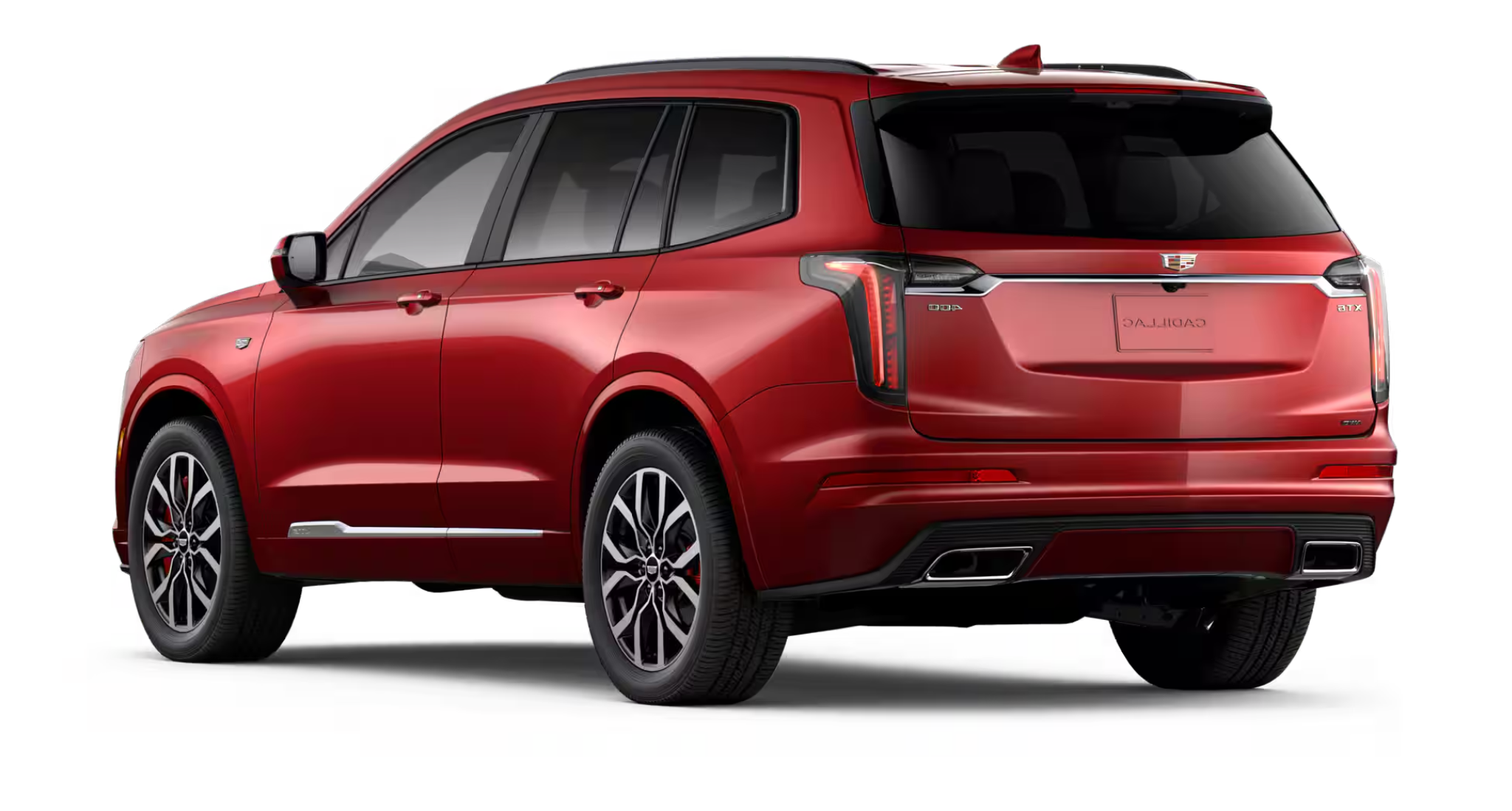 Rear view of the 2025 Cadillac XT6 Luxury AWD highlighting LED taillights, rear spoiler, dual exhaust outlets, and bold SUV design.