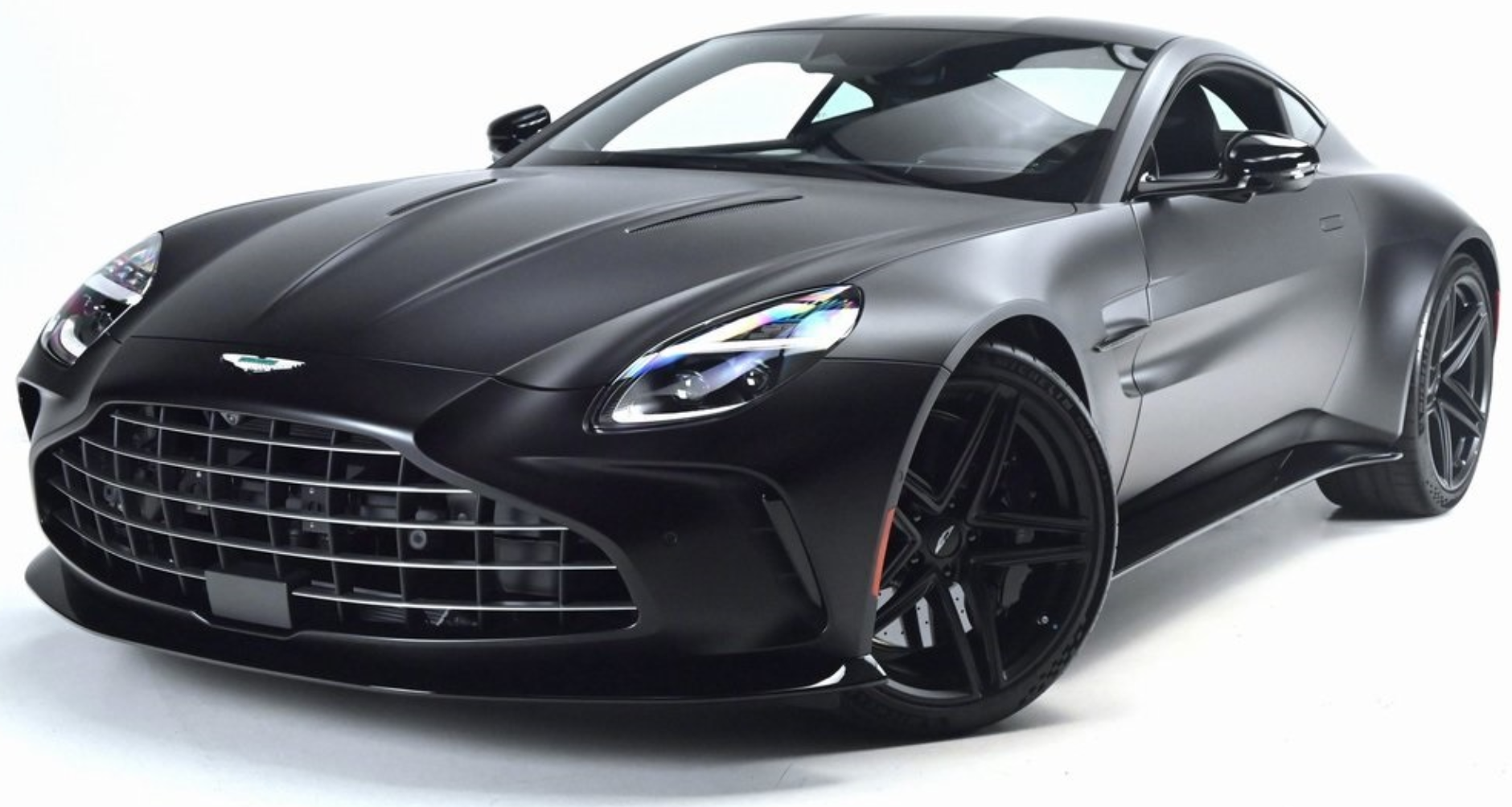 Front view of the 2025 Aston Martin Vantage Coupe in matte black showcasing aggressive grille, LED headlights, and aerodynamic design.