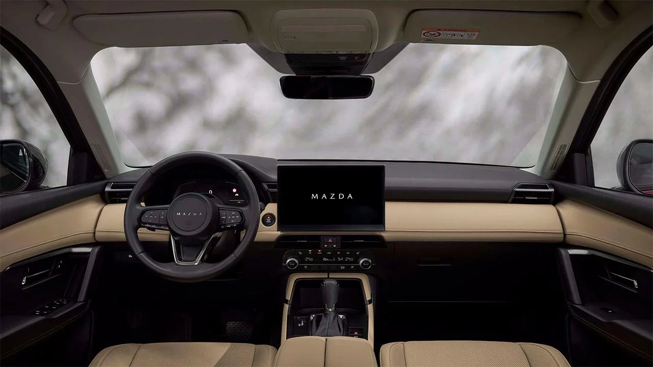 2026 Mazda CX-5 AWD interior with large touchscreen infotainment, Mazda steering wheel and tan leather dashboard